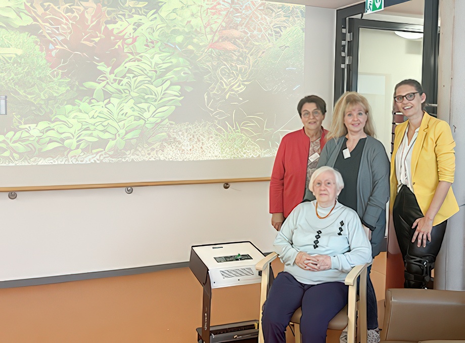 Evdiak Mitabeiterinnen und Bewohnerin und Qwiek.up Projektor mit angestrahlter Wand