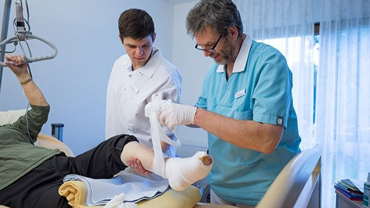 Evdiak Bild von zwei Mitarbeitern, die einen Fuß verbinden