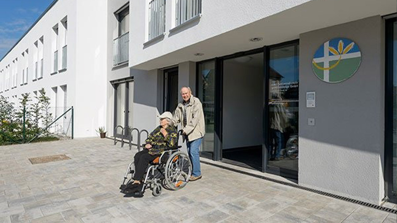 Evdiak Bild von einem Mann und einer Frau im Rollstuhl vor der Einrichtung