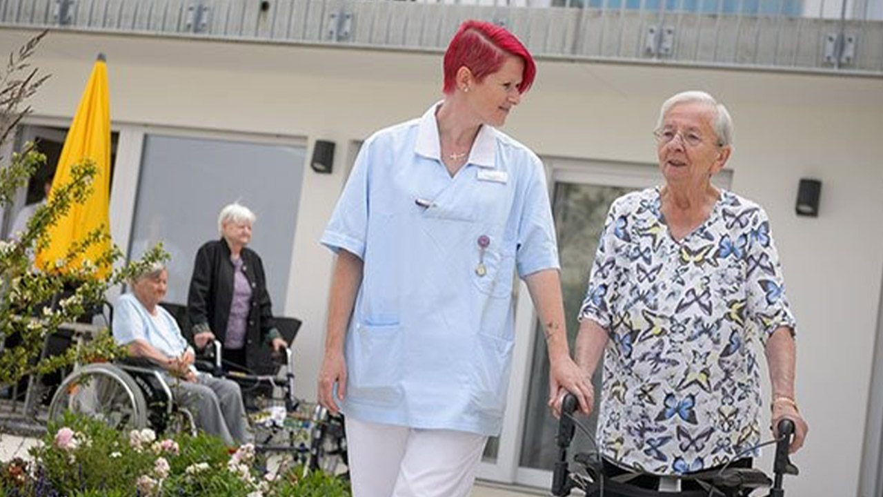 Evdiak Bild von zwei Frauen im Vordergrund, einer Seniorin und einer Pflegerin