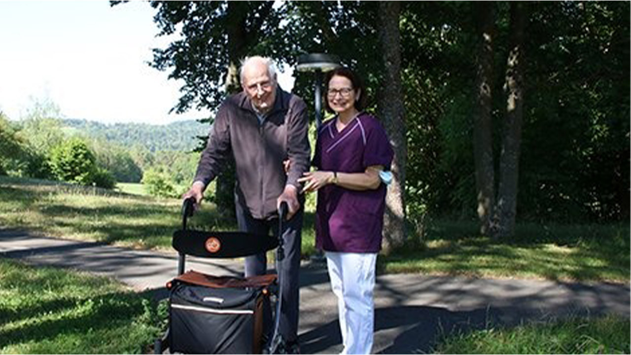 Evdiak Bild eines Seniors und einer Mitarbeiterin, bei einem Spaziergang