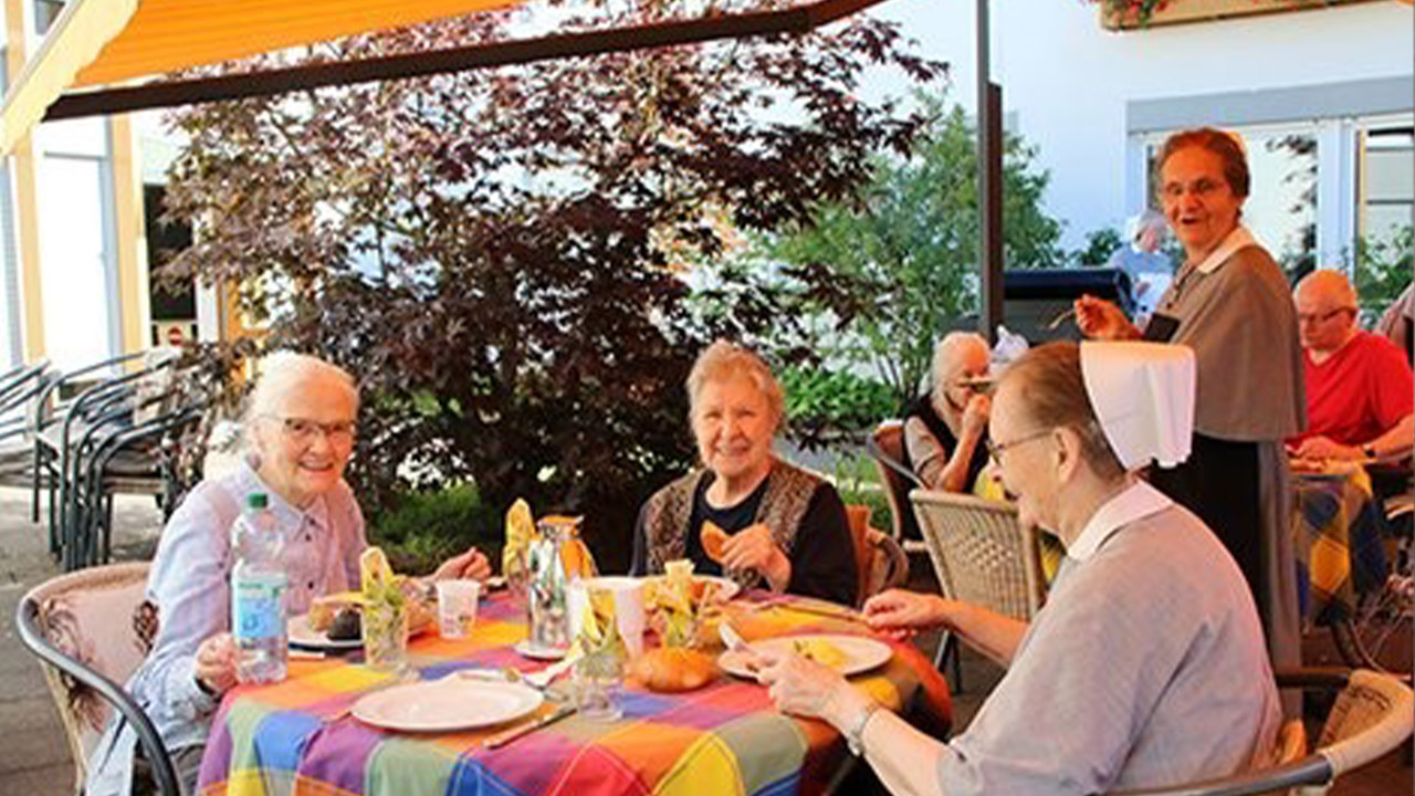 Evdiak Bild von mehreren Frauen an Tischen auf einer Terasse