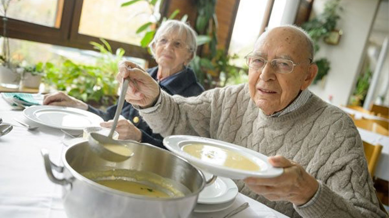 Evdiak Bild zweier Senioren, die sich Suppe schöpfen