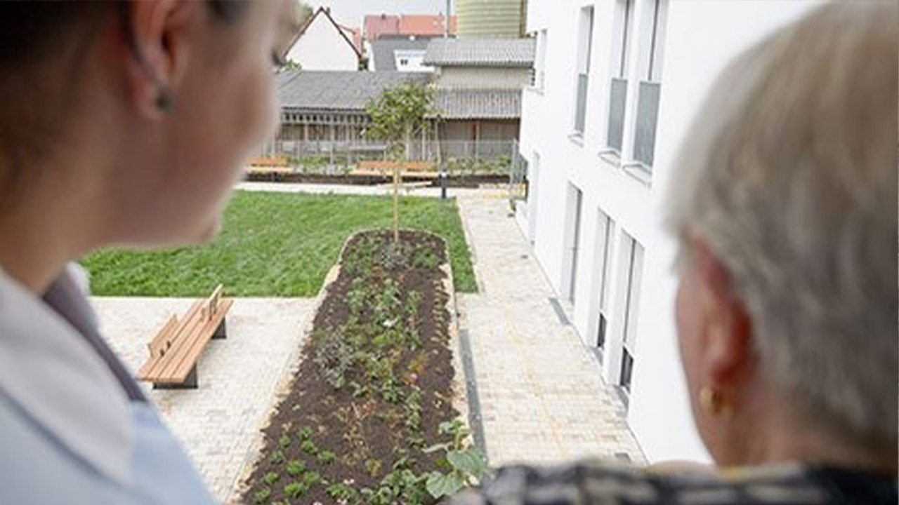 Evdiak Bild zweier Personen, die vom Balkon auf den Garten schauen