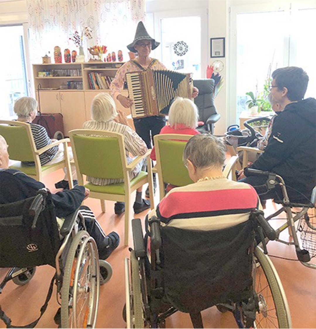 Evdiak Bild von einem Mann mit Akkordion und Senioren, die ihm zuschauen