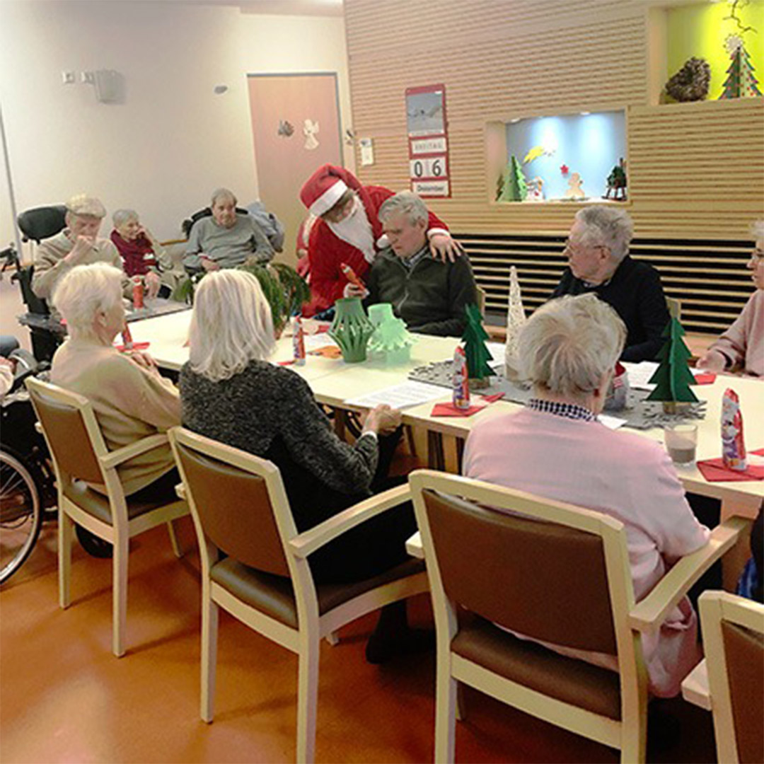 Evdiak Bild von einer Mitarbeiterin im Nikolaus Kostüm, die Schokoladen Nikoläuse verteilt