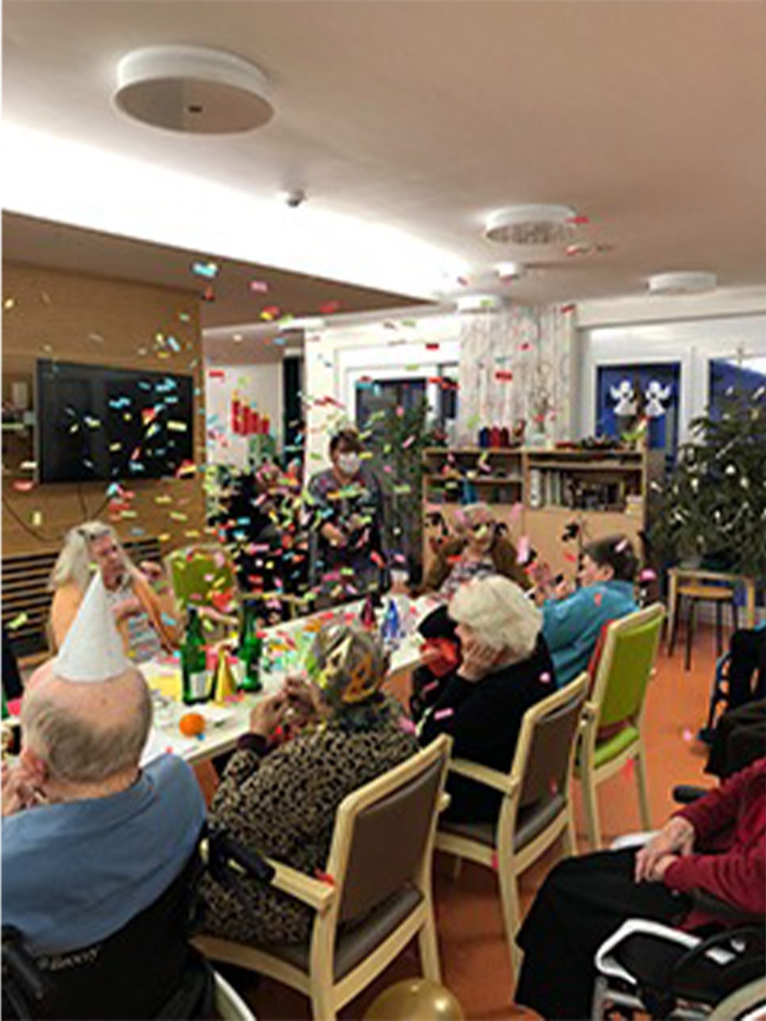 Evdiak Bild von Senioren mit Partyhüten auf dem Kopf und Konfetti friegt in der Luft