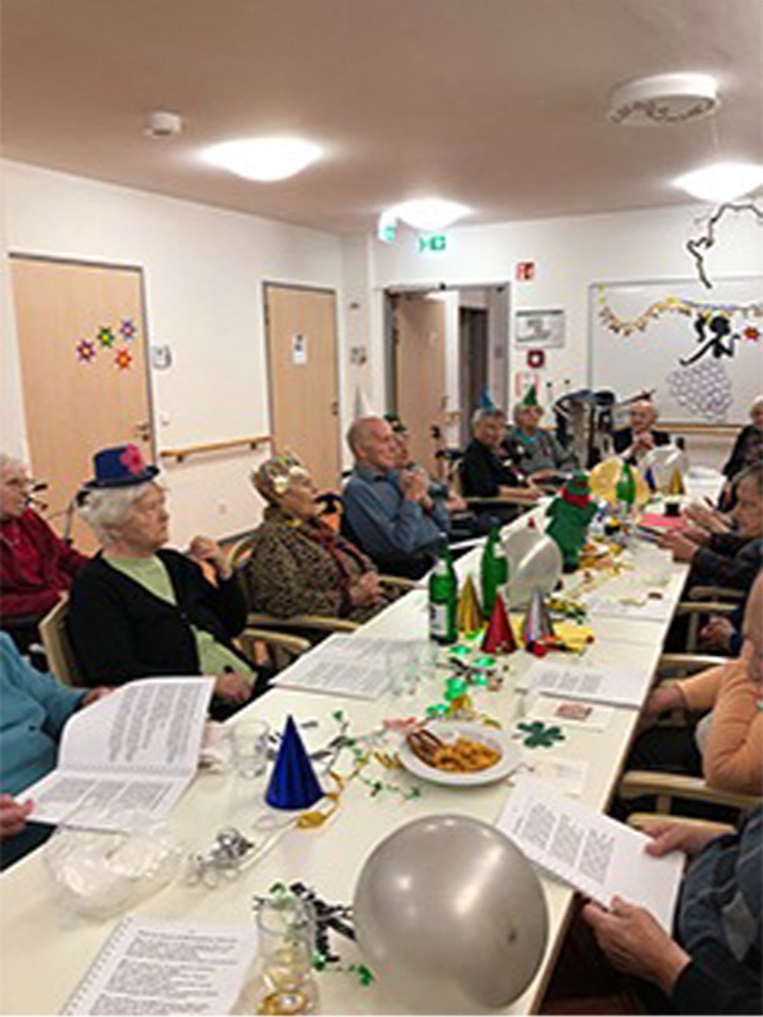 Evdiak Bild von Senioren an einem langen Tisch sitzend mit Partydekoration