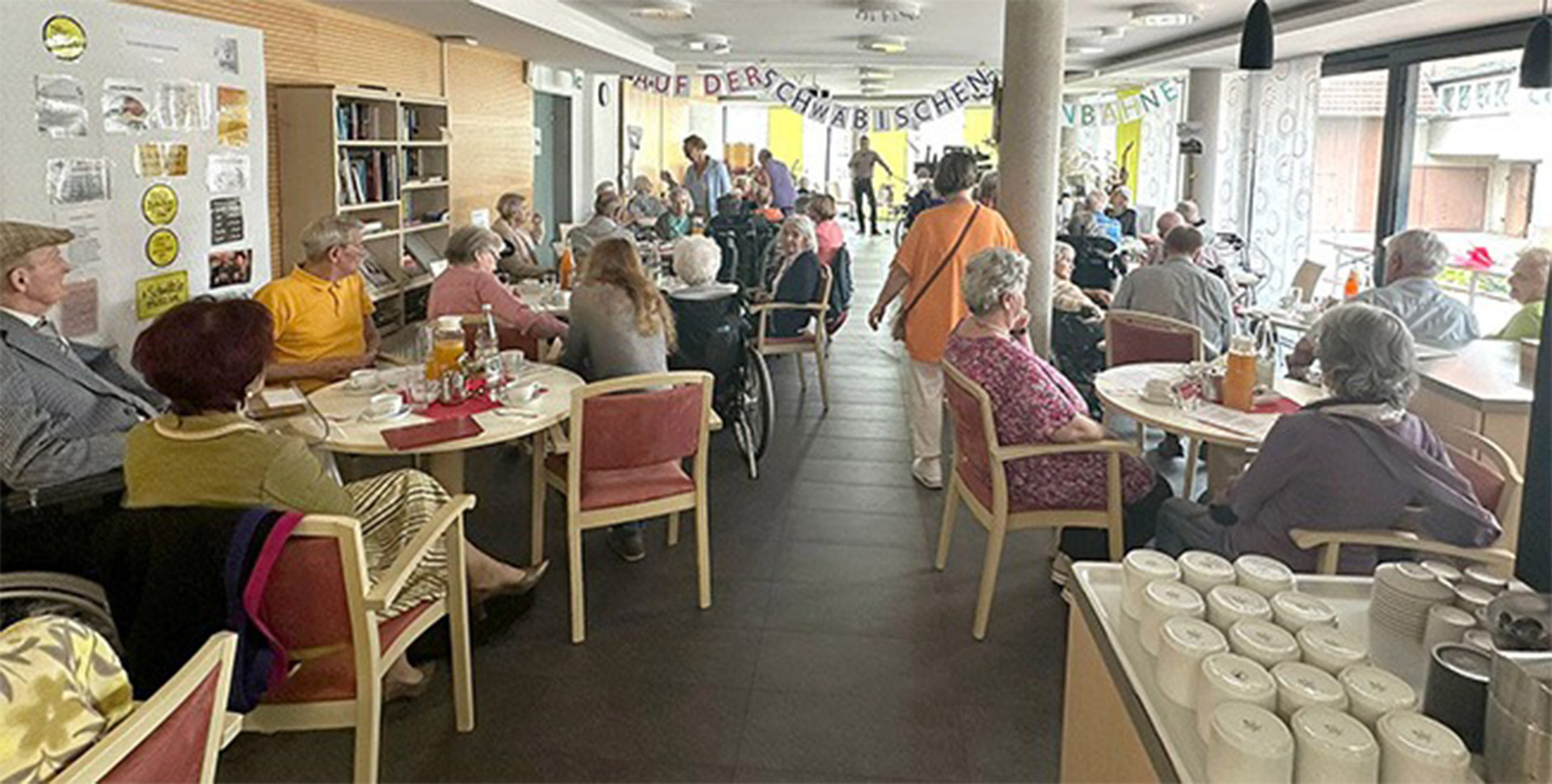 Evdiak Bild von Personen auf einer Bühne und einem Seniorenpublikum