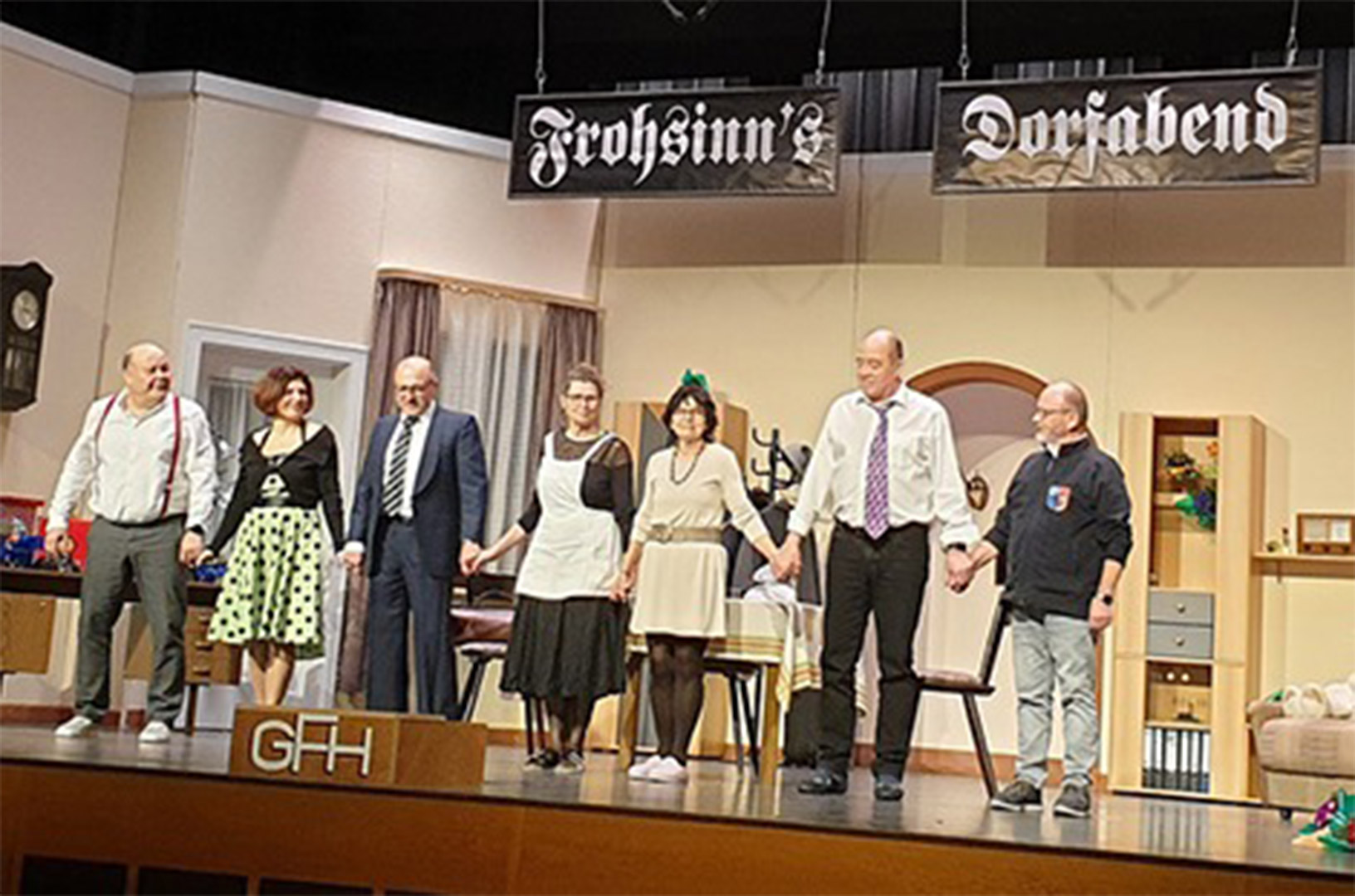 Evdiak Bild von Personen auf einer Bühne, die sich an den Händen nehmen um sich zu verbeugen