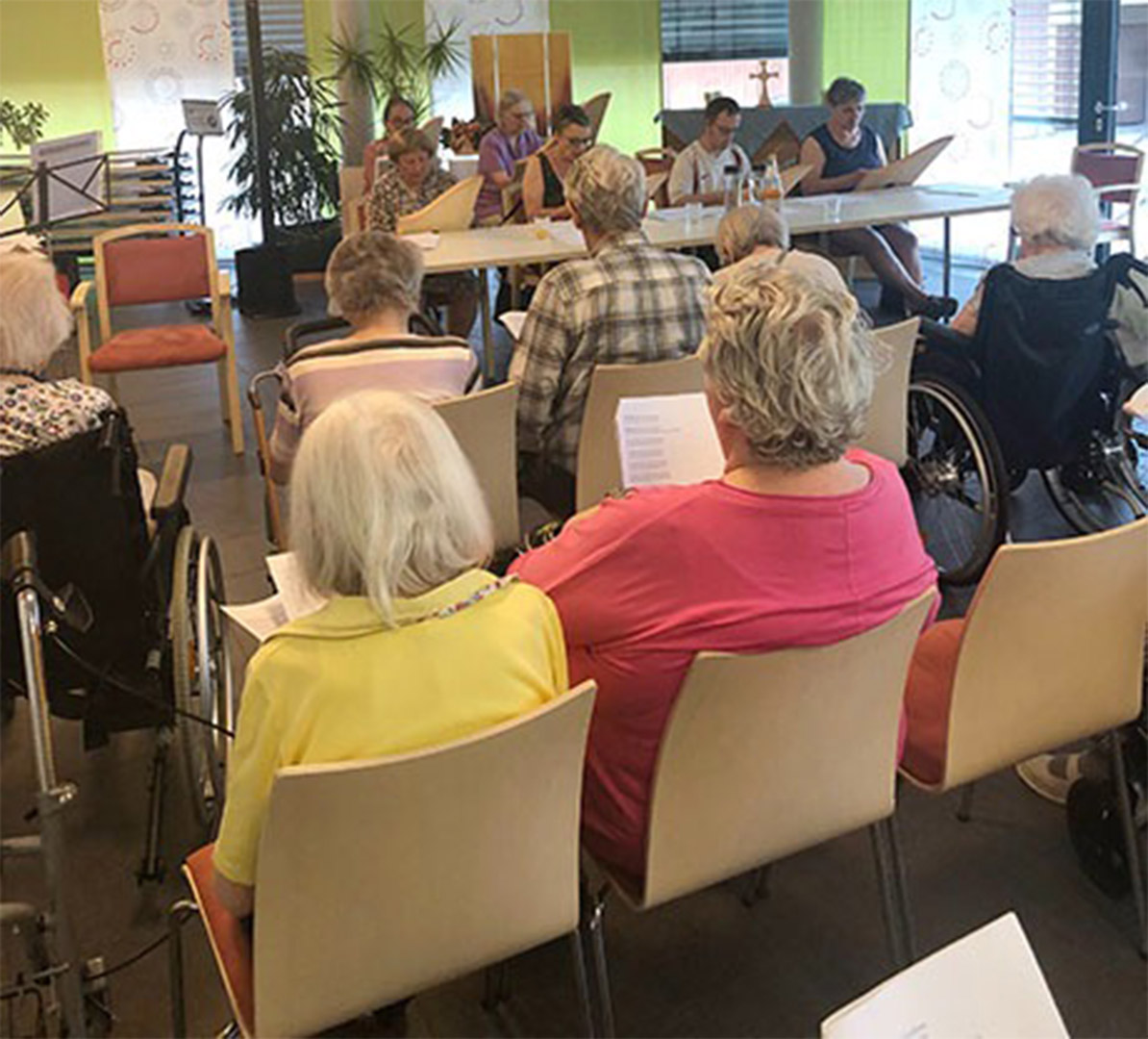 Evdiak Bild von Senioren sitzend in Stuhlreihen, die singen
