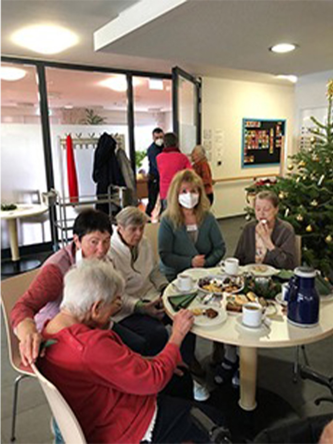 Evdiak Bild von Senioren an einem runden Tisch mit Plätzchen und Tee