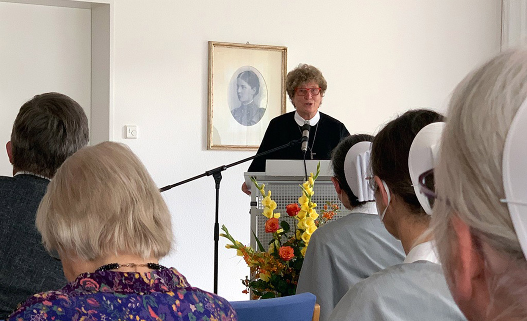 Evdiak Bild von einer Mitarbeiterin auf einer Bühne an einem Rednerpult