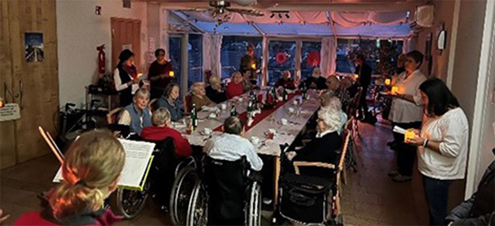 Veranstaltung-PAR-Adventssonntag Evdiak Bilder eines Tisches mit Senioren, Adventskerzen und einer Person, die musiziert