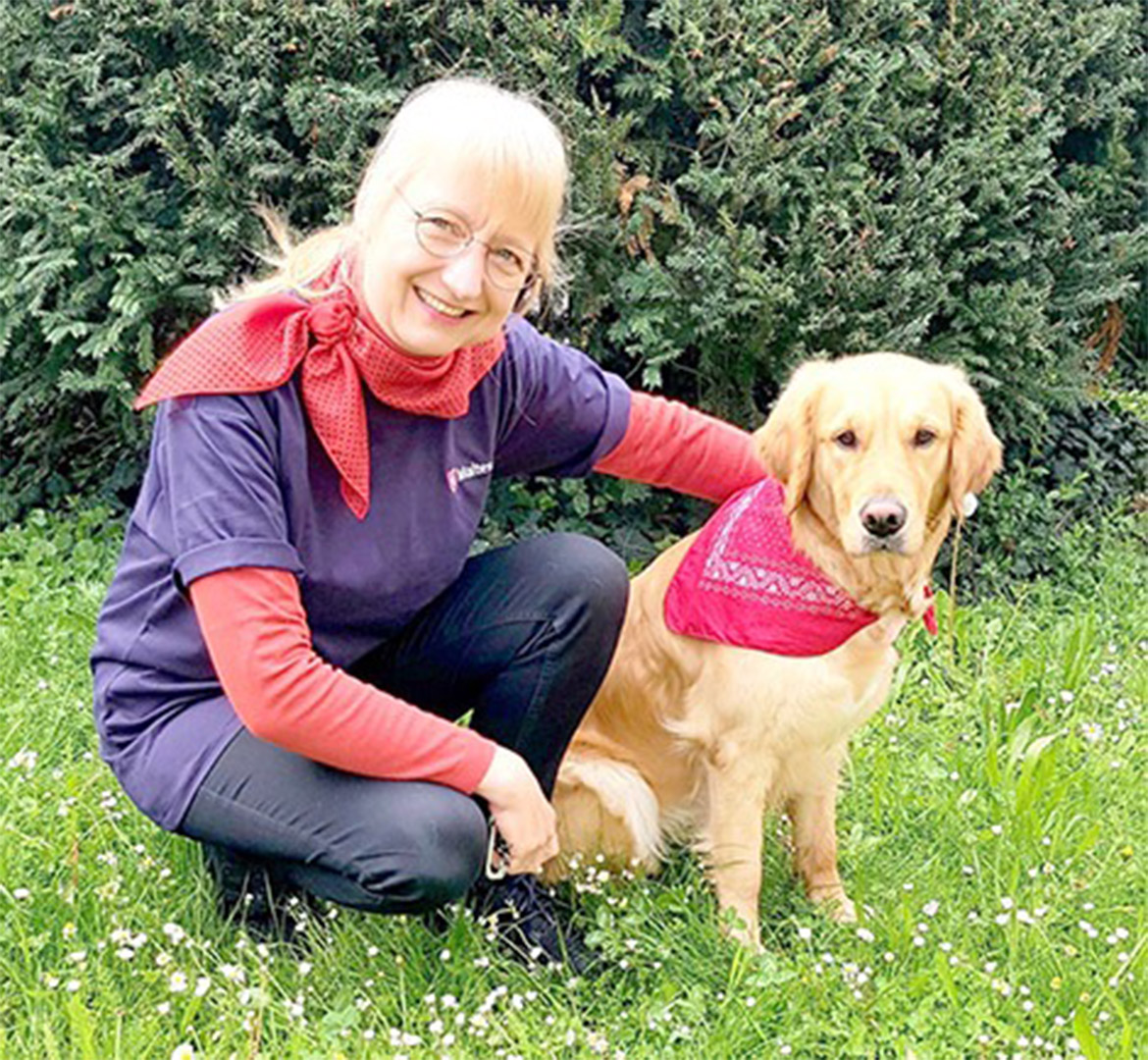 EVDIAK Bild von einer Frau, die neben ihrer Hündin kniet