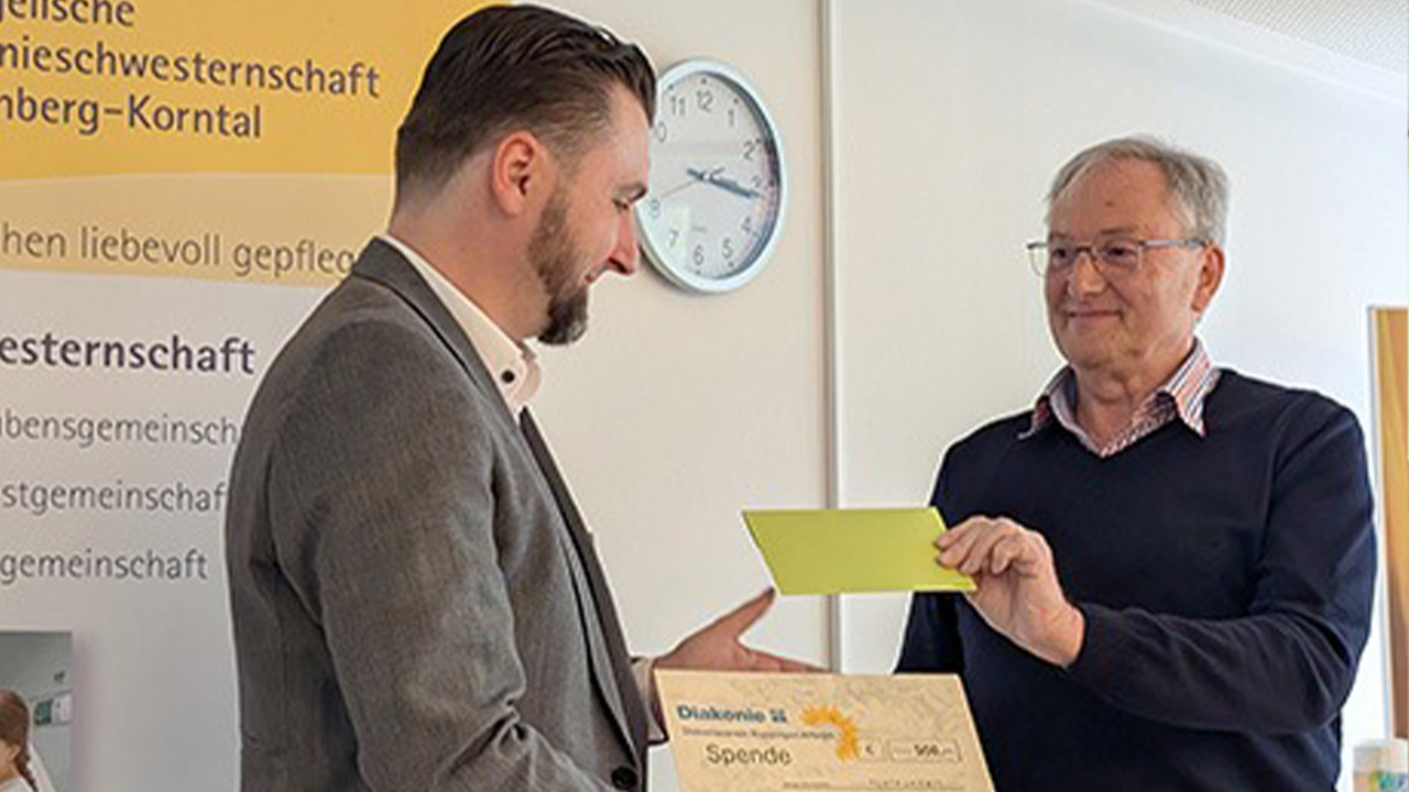 Evdiak Bild, der eine Mann überreicht dem anderen eine Spendenbescheinigung