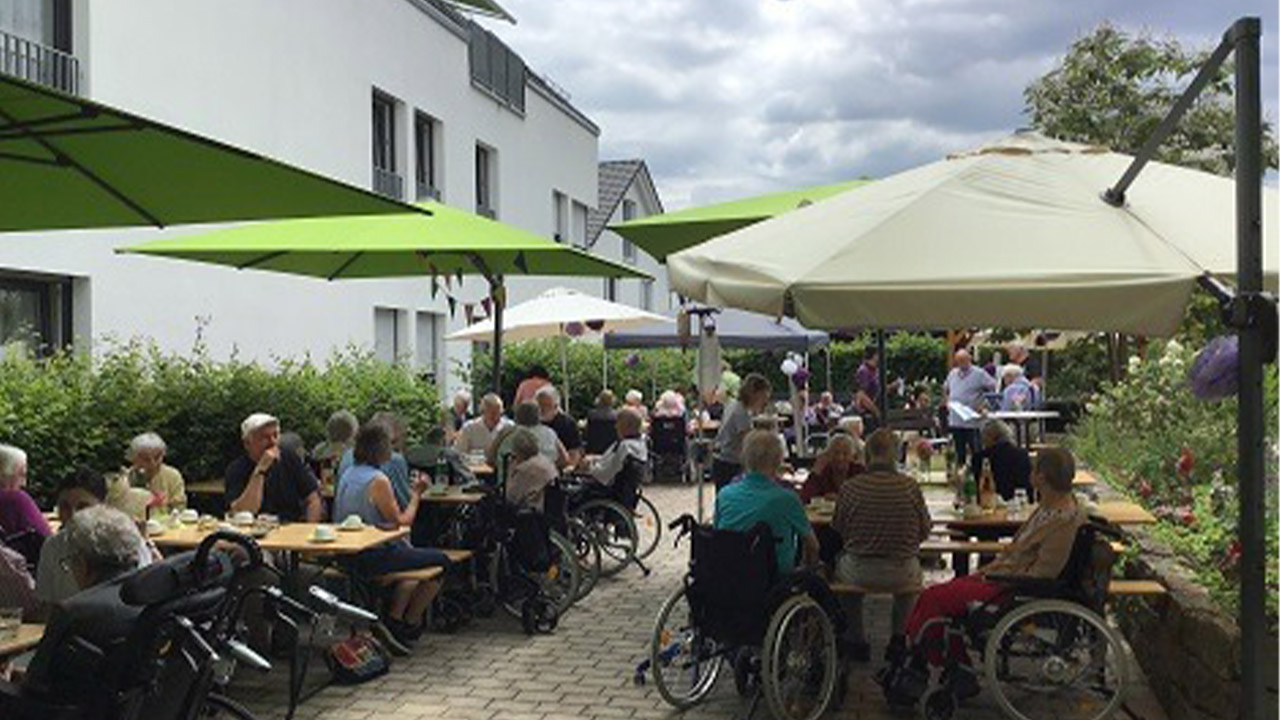 Evdiak Bild von vielen Senioren unter Sommerschürmen