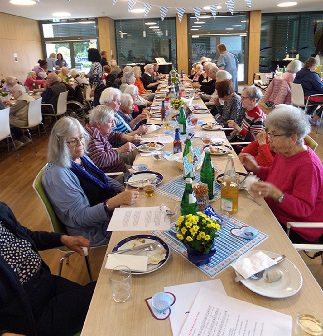 Evdiak Bild von einer langen Tafel, an der Senioren sitzen