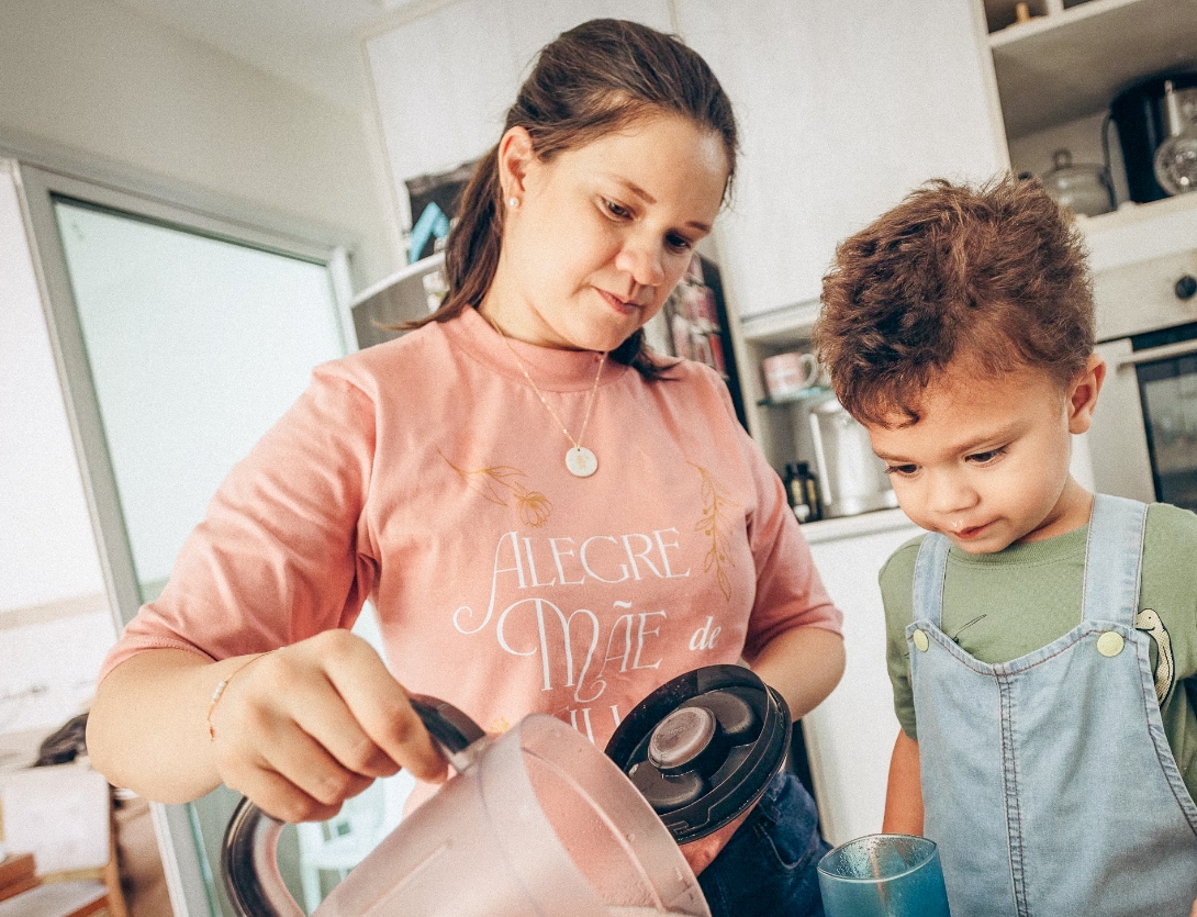 Evdiak Berufsfachschülerin bereitet mit kleinem Jungen einen Erdbeershake in der Küche zu