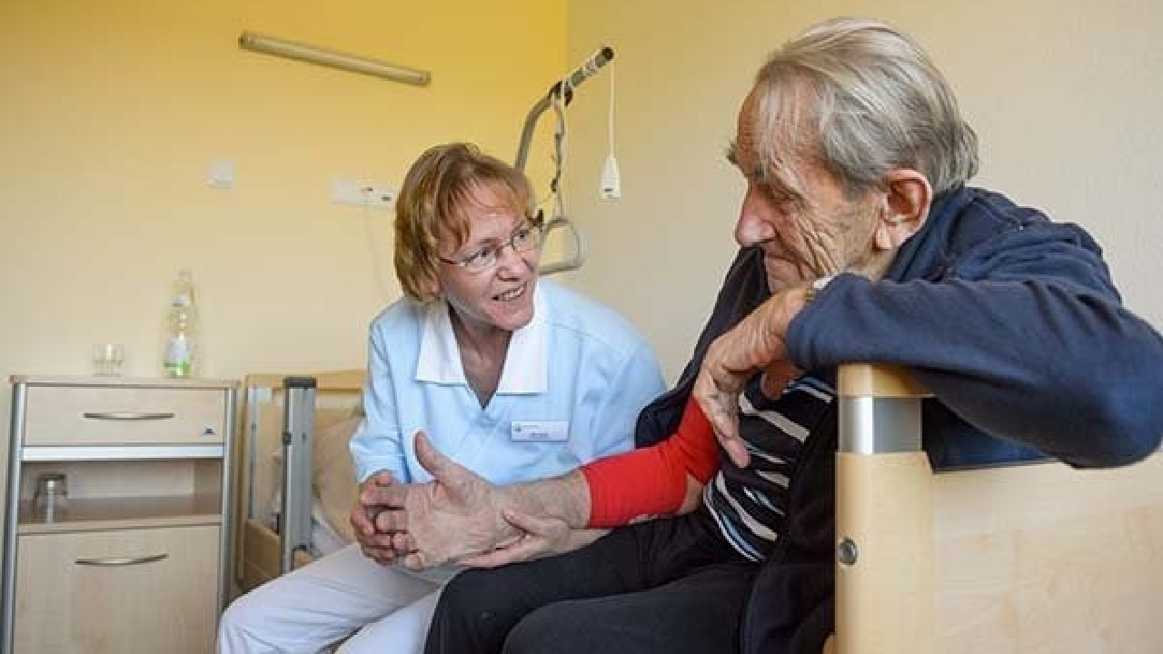 Evdiak Pflegerin und Bewohner in fürsorglicher Geste