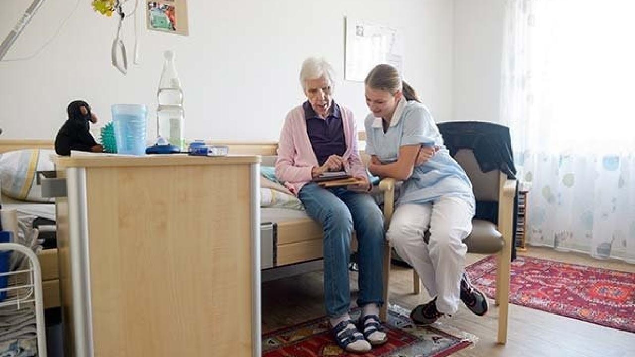 Evdiak Pflegerin und Bewohnerin gemeinsam beim Durchgehen von Unterlagen