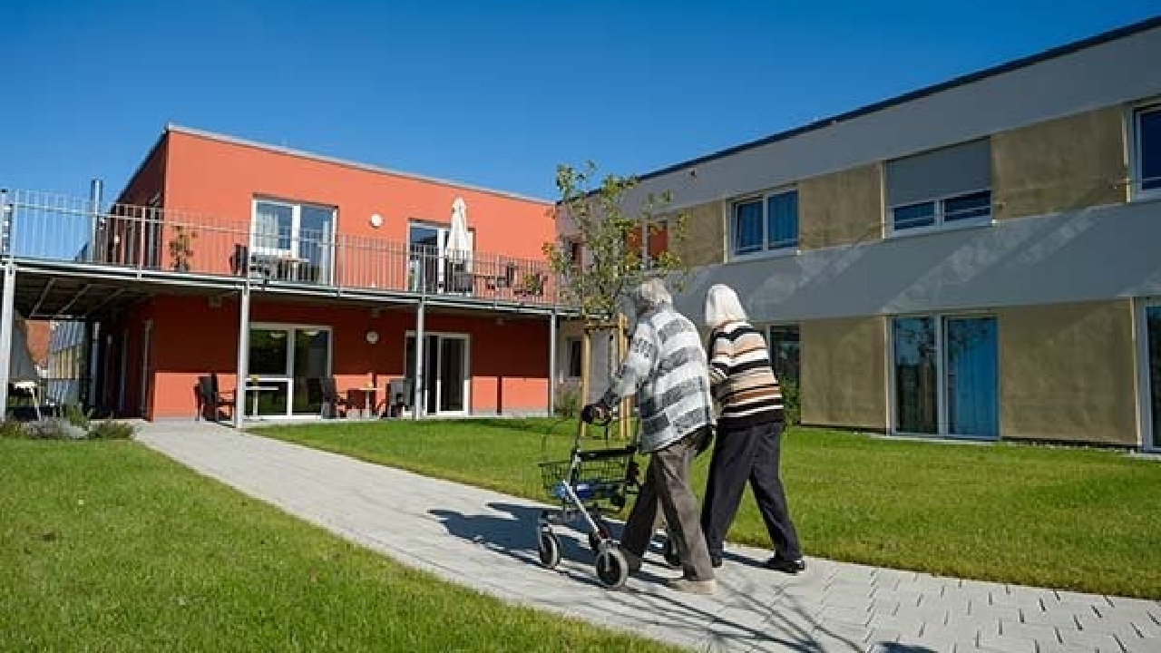 Evdiak Bewohnerin und Besucherin beim gemeinsamen Spaziergang durch die schön gepflegten Grünanlagen der Einrichtung