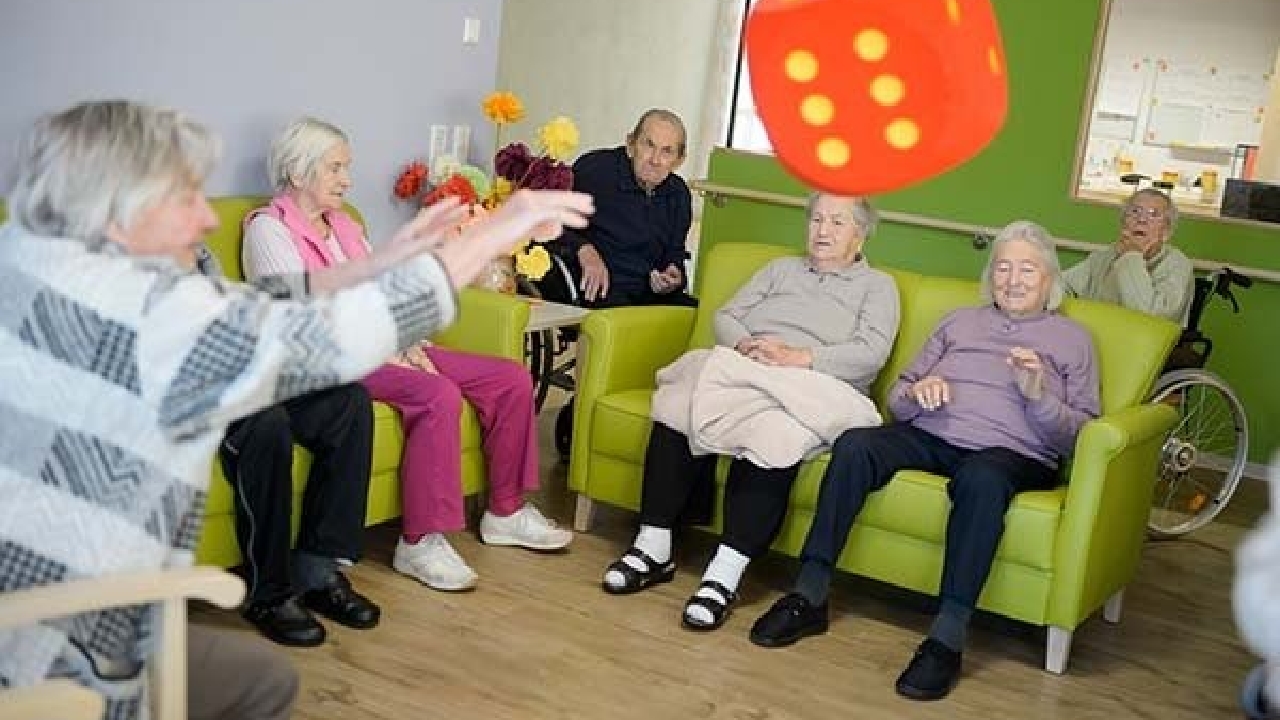 Evdiak Heitere Seniorenrunde beim Spielen mit einem Schaumstoffwürfel
