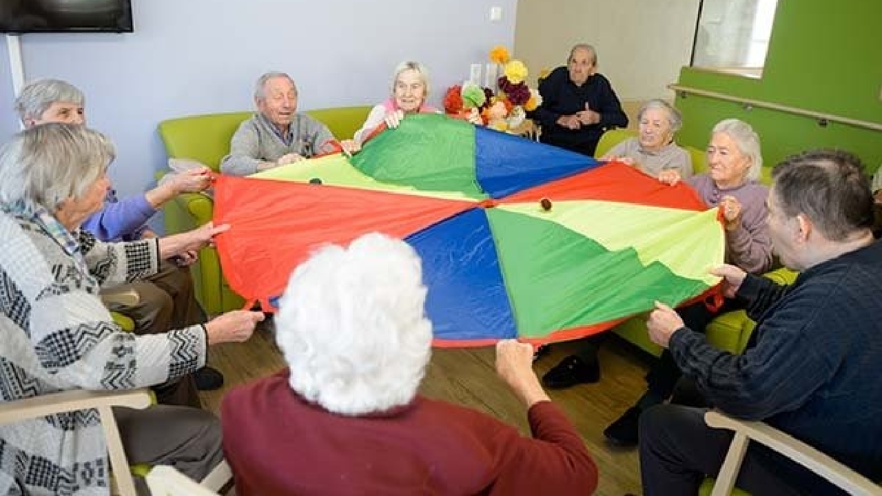 Evdiak Heitere Seniorenrunde bei gemeinsamer Aktivität mit einem bunten Schwungtuch